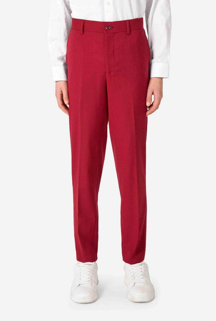 Teen boy wearing a stylish burgundy red suit with a white dress shirt, looking confidently. Perfect formal outfit for boys' special occasions, weddings, and parties. Close up pants.