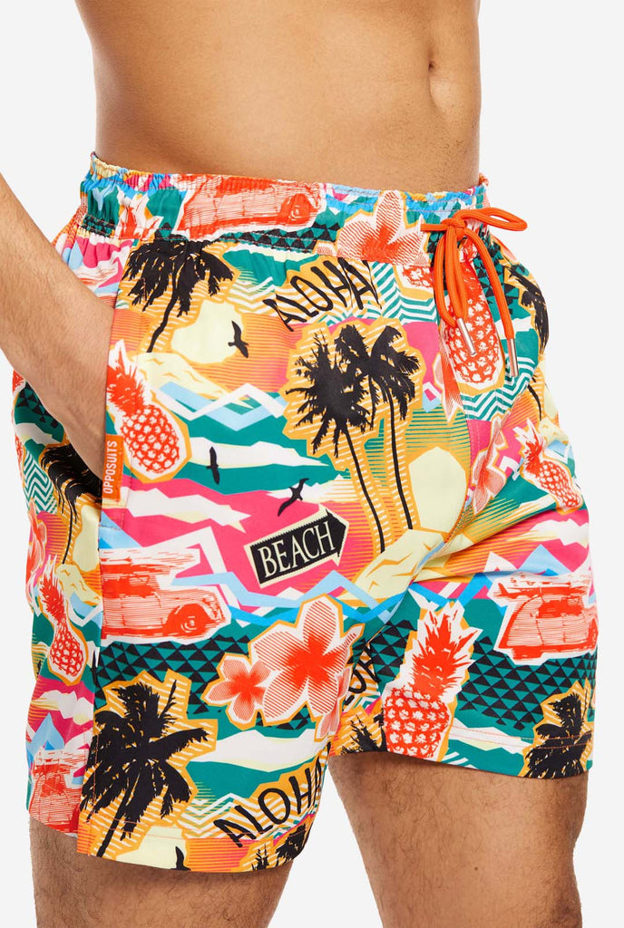 Man wearing swim trunks with tropical Hawaiian print, close up