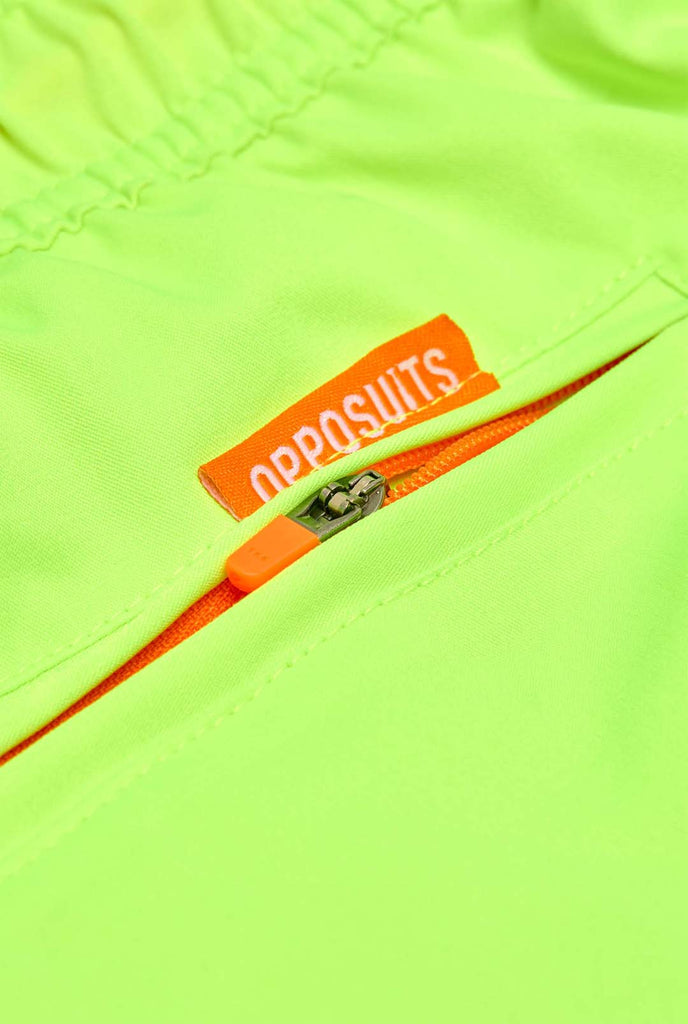 Man wearing Neon lime green swim trunks for men, close up