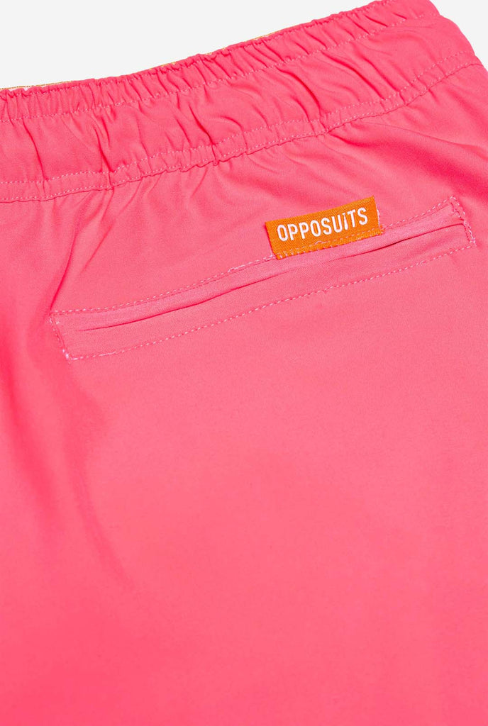 Man wearing Neon Pink Power swim trunks for men, close up