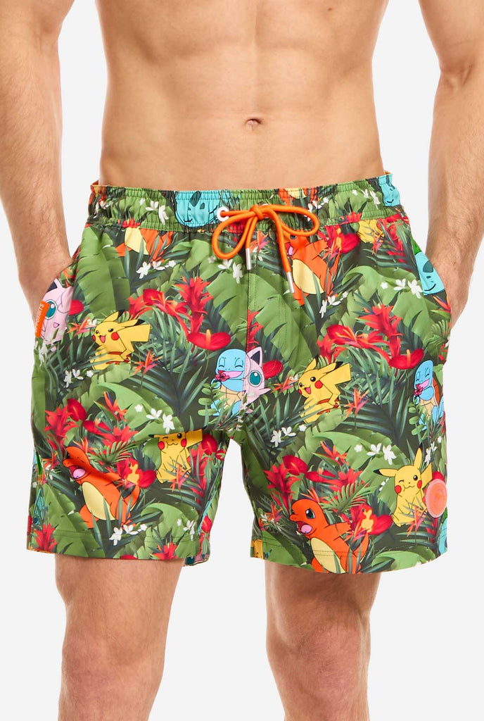 Man wearing swim trunks with Pokemon forest print, close up