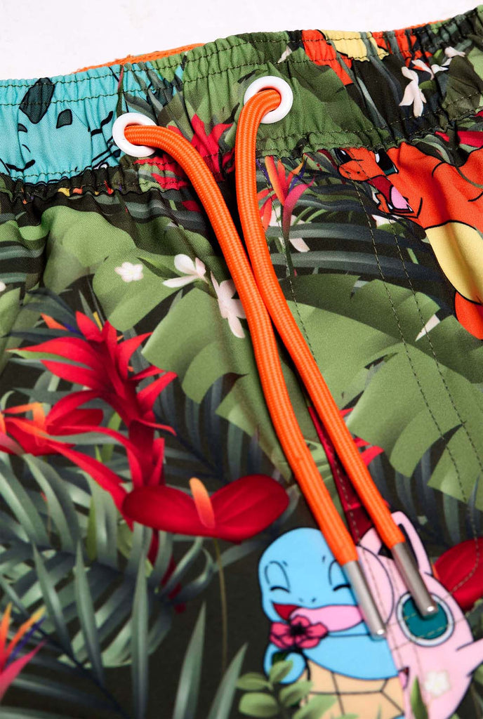 Man wearing swim trunks with Pokemon forest print, close up