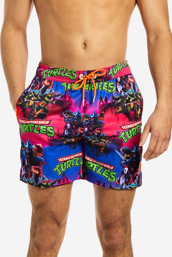 Man wearing TMNT Dude swim trunks for men, close up