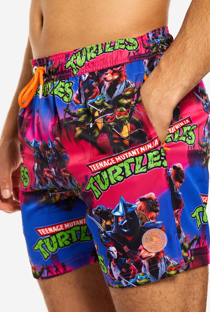 Man wearing TMNT Dude swim trunks for men, close up