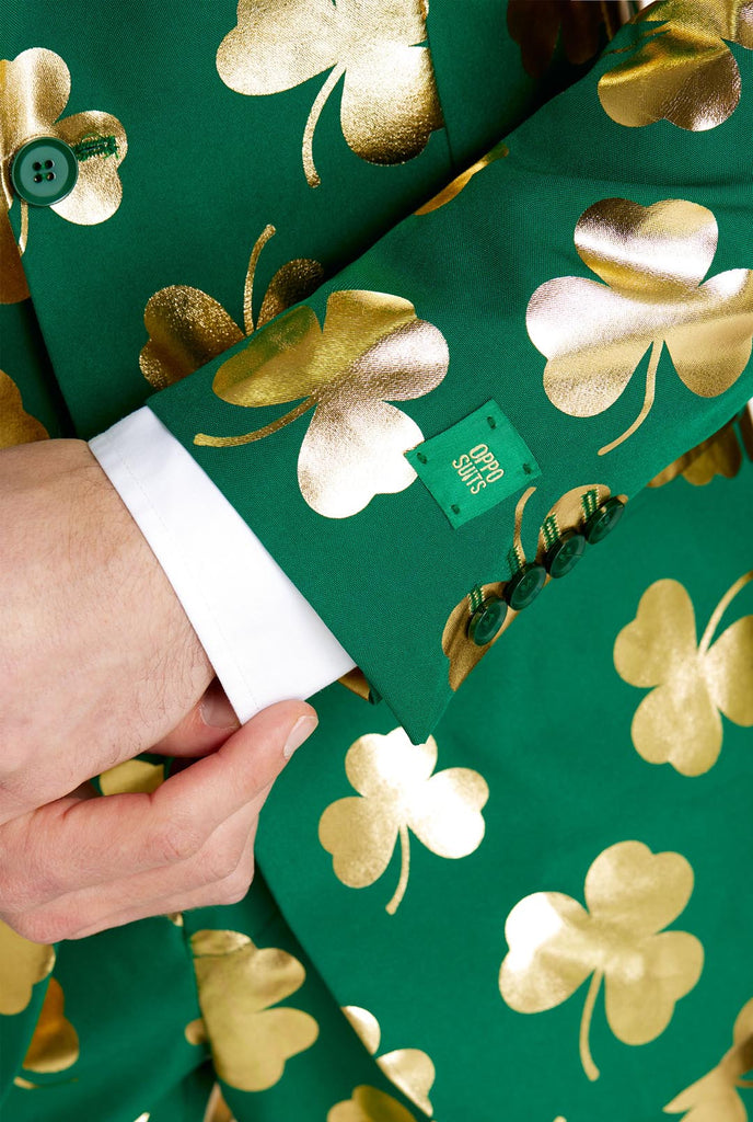 Man wearing green St Patrick's Day suit with golden clovers, close up.