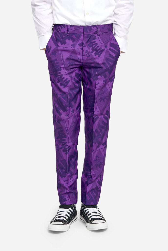 Teen wearing purple teen boys suit with a The Joker theme. Further he is wearing a white shirt. Hands in pockets of pants. Close up of the pants.