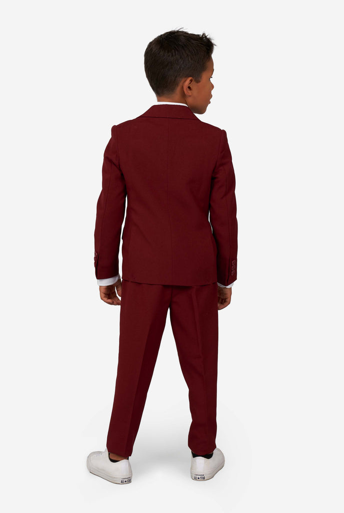 Kid wearing a burgundy red suit for boys, view from the back