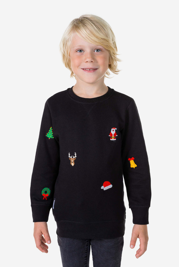 Kid wearing black Christmas sweater with Christmas icons