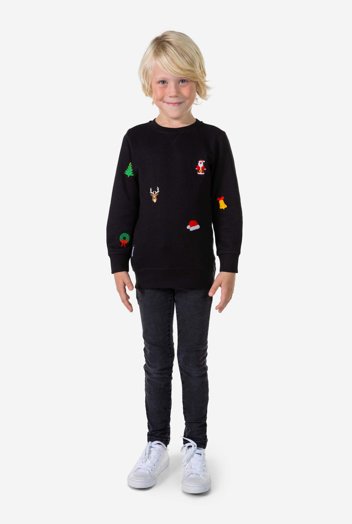 Kid wearing black Christmas sweater with Christmas icons