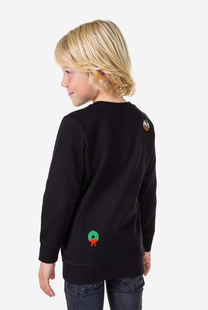 Kid wearing black Christmas sweater with Christmas icons, view from the back