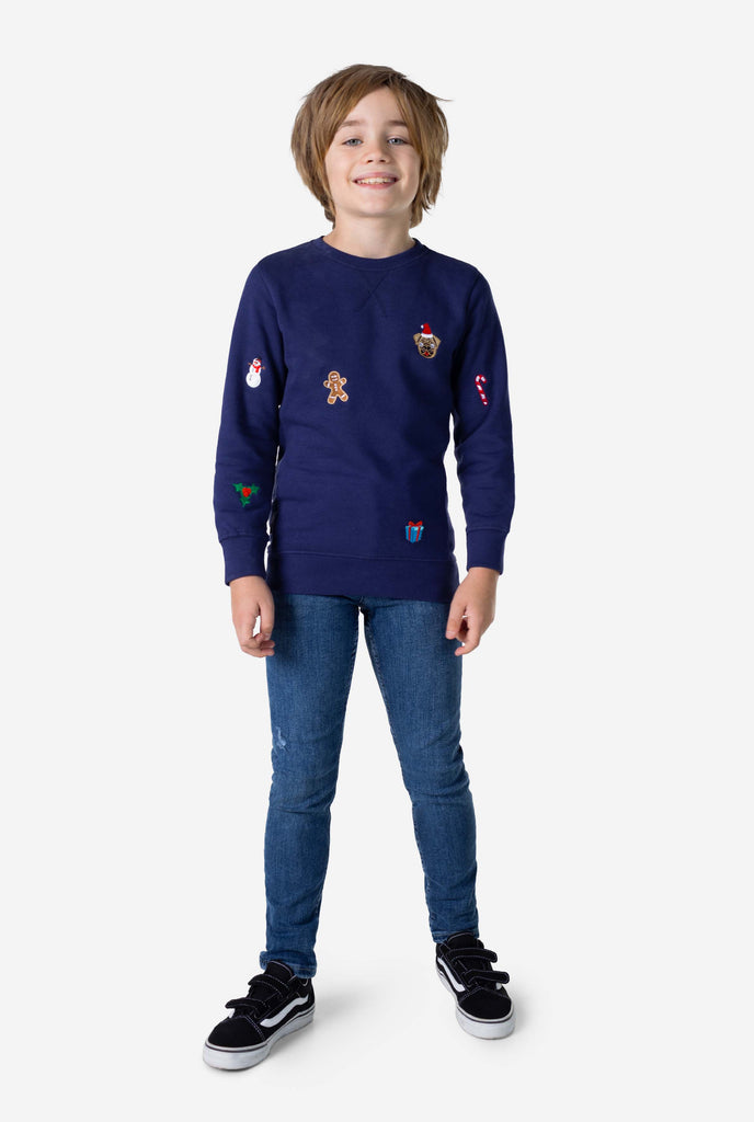 Kid wearing blue Christmas sweater with Christmas icons