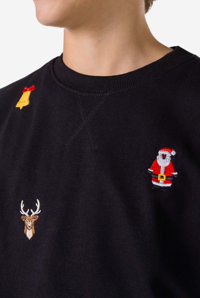 Teen wearing black Christmas sweater with Christmas icons, close up