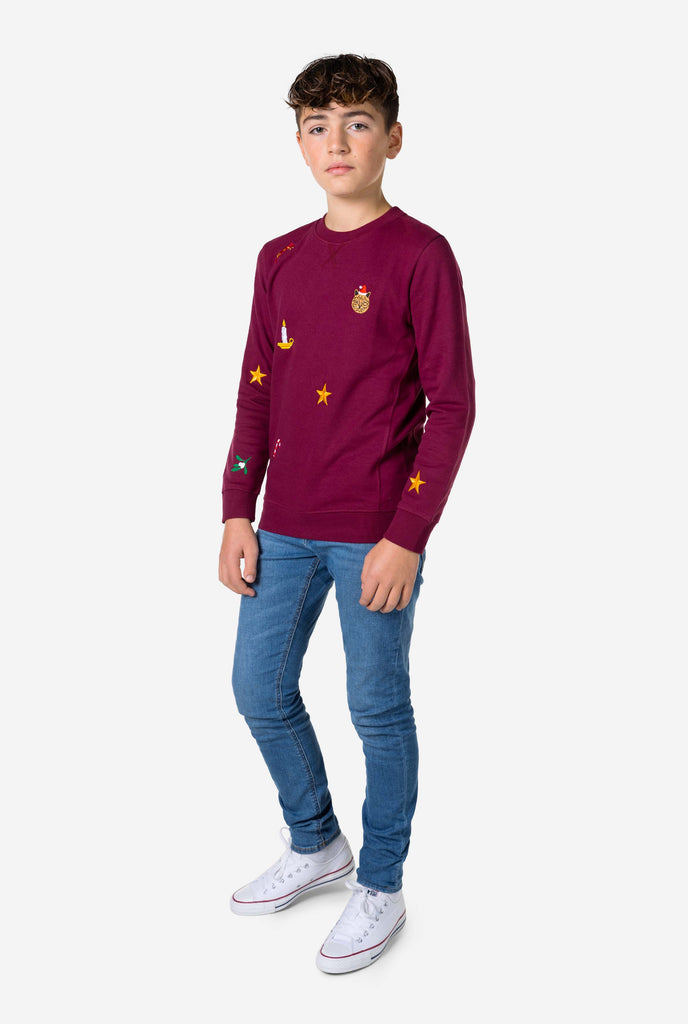 Kid wearing burgundy red Christmas sweater with Christmas icons