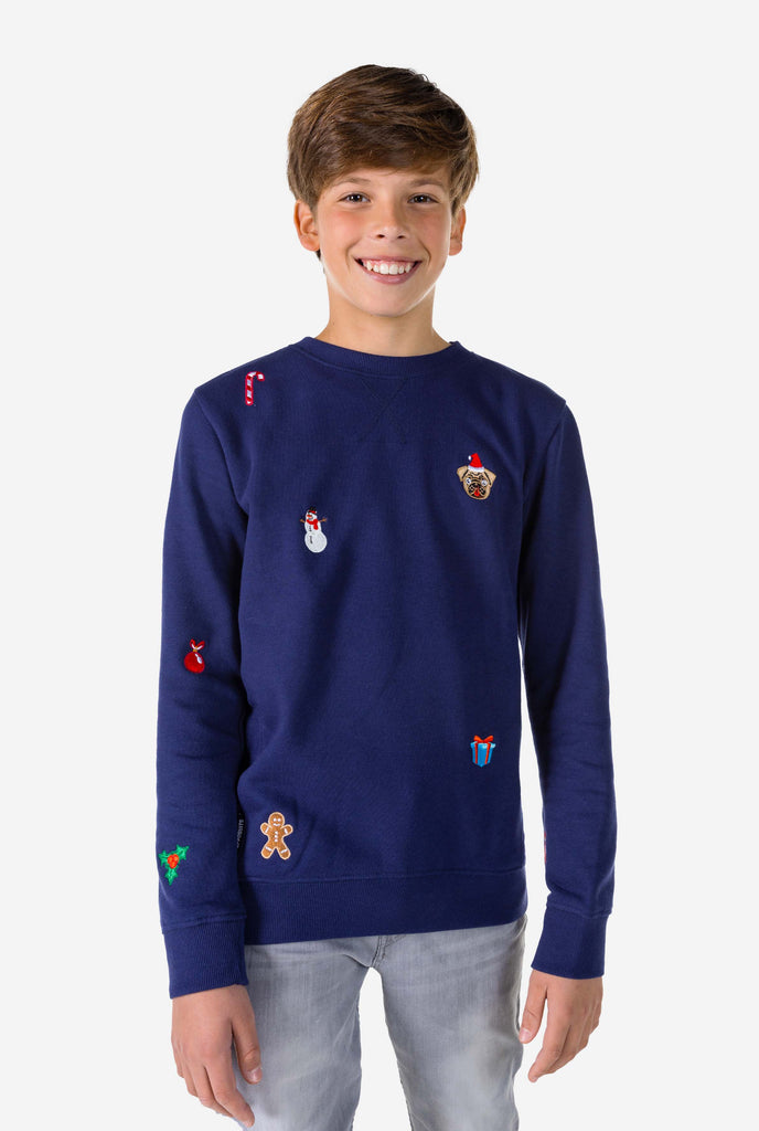Kid wearing blue Christmas sweater with Christmas icons
