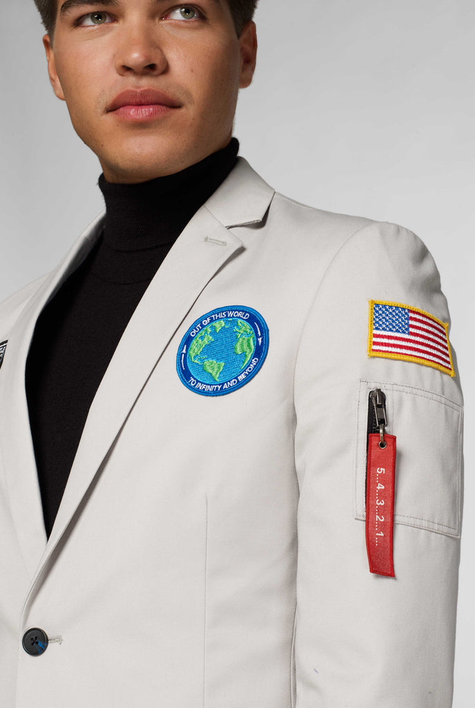 Light grey blazer with astronaut themed patches worn by man