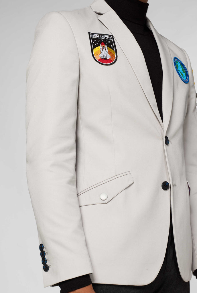 Grey blazer with astronaut themed patches shown up close