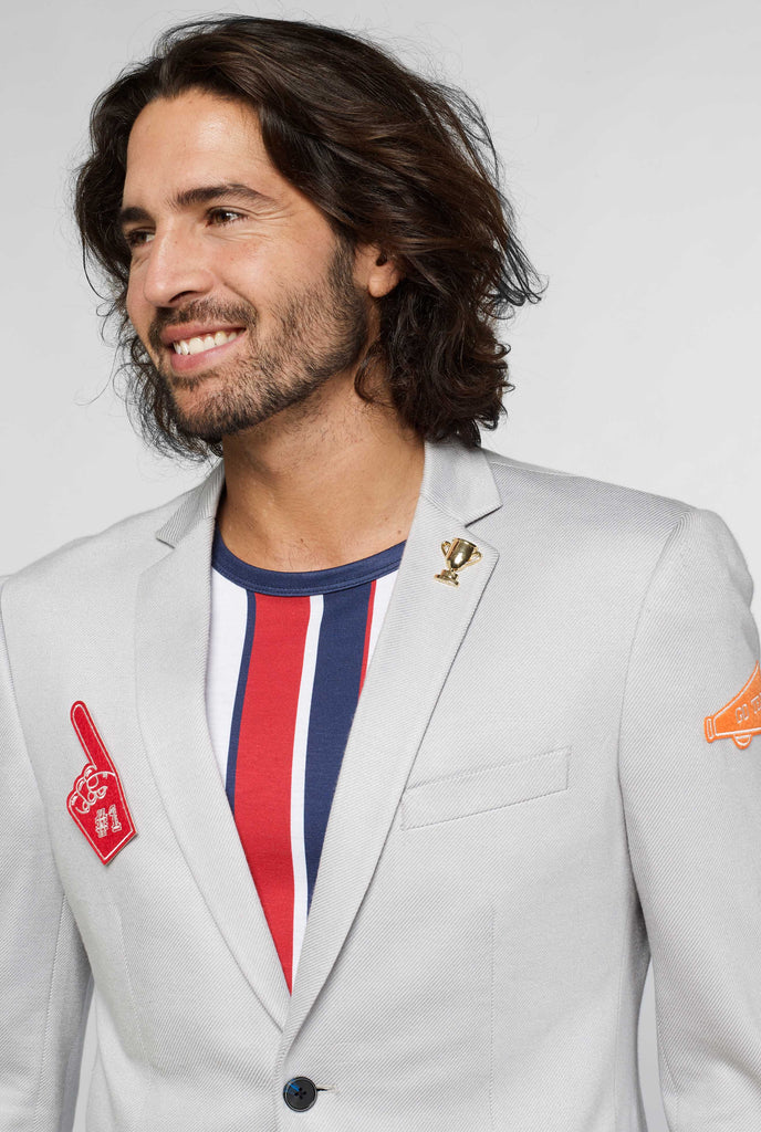 Grey sportswear blazer with sports patches worn by man