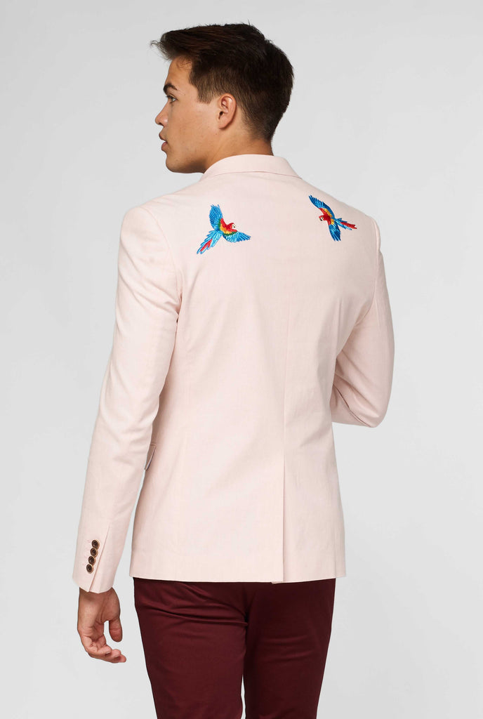 Pink blazer with parrot embroidery worn by man showing back of blazer