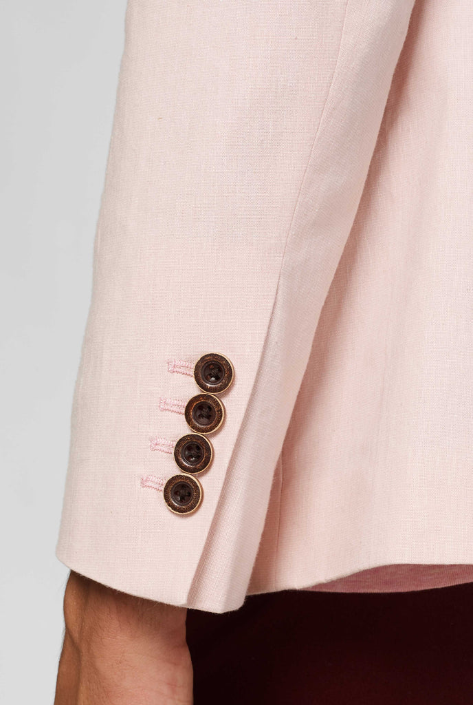 Pink blazer with parrot embroidery worn by man close up of sleeve