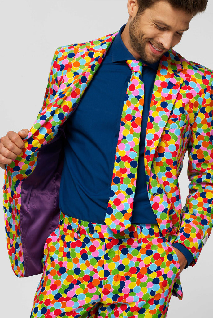 Man wearing men's suit with confetti print and blue dress shirt