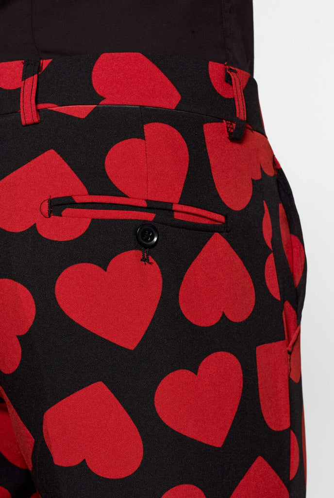 Man wearing black suit with red hearts print, close up