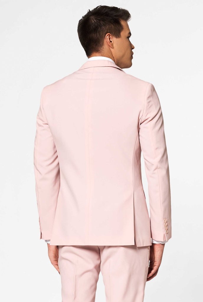 Man wearing pastel pink colored men's suit, view from the back