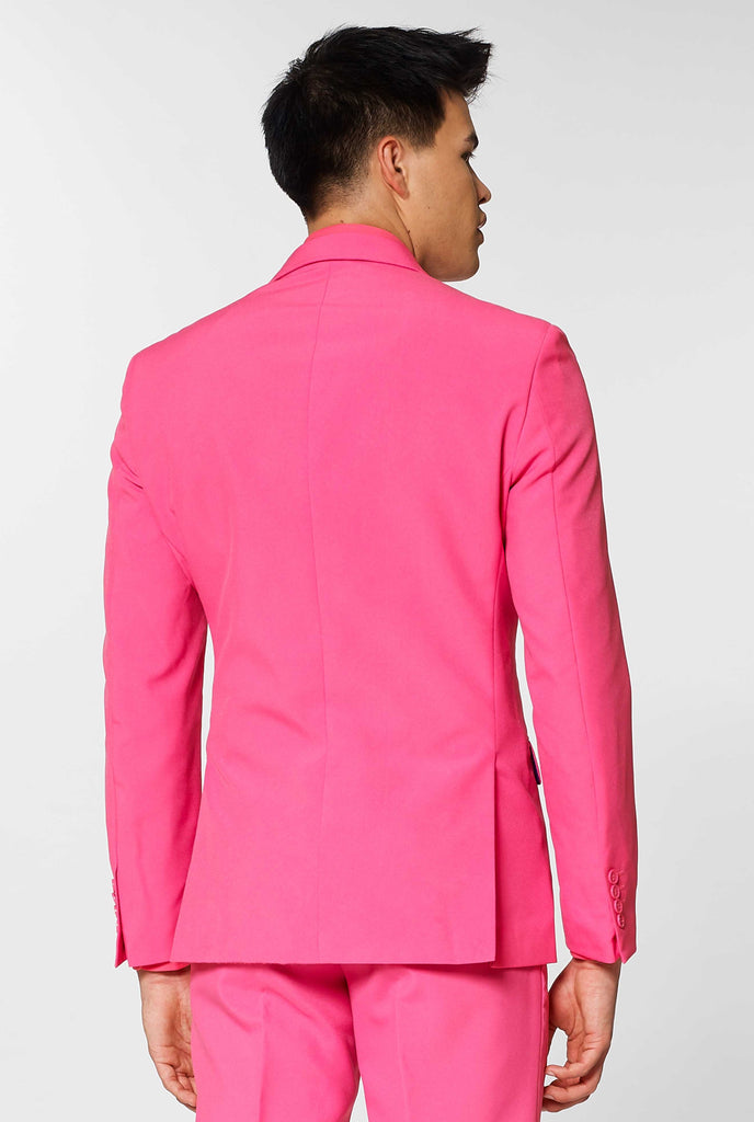 Man wearing pink men's suit with pink dress shirt, view from the back