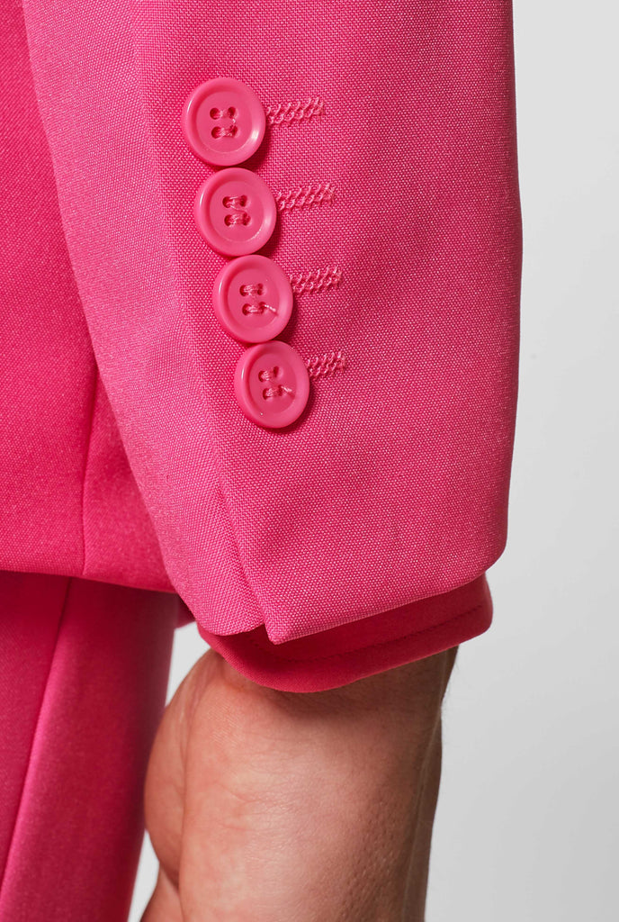 Man wearing pink men's suit with pink dress shirt, sleeve close up