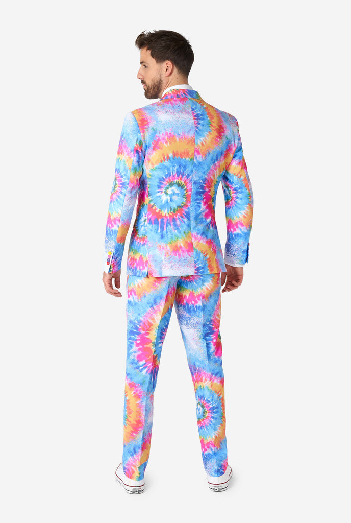 Man wearing pride men's suit with colorful tie dye rainbow print, view from the back