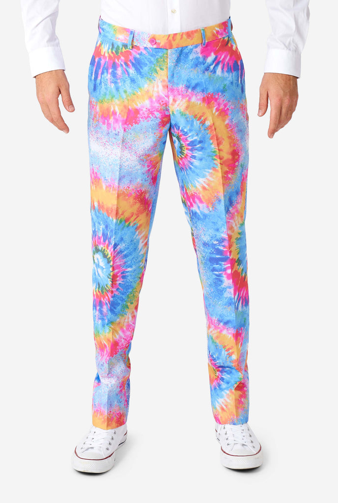 Man wearing pride men's suit with colorful tie dye rainbow print, zoomed in on pants