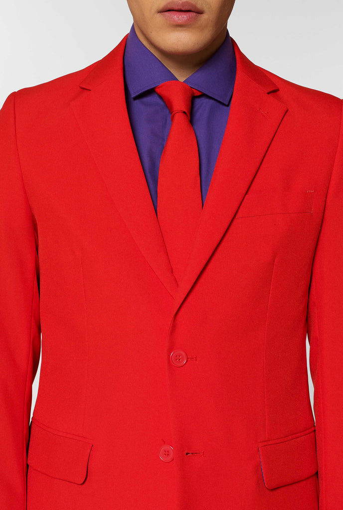 Man wearing red men's suit with purple dress shirt, close up