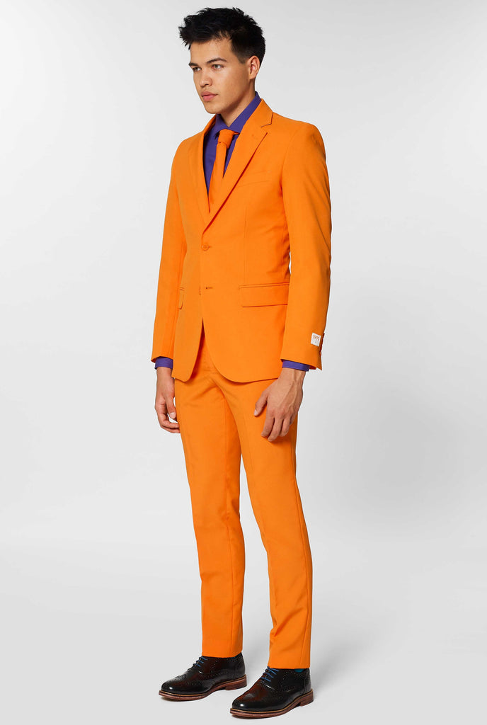 Man wearing orange men's suit with purple dress shirt