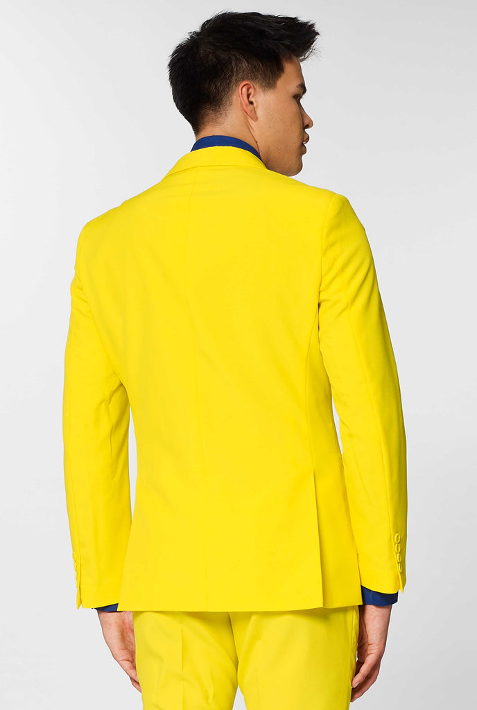 Man wearing yellow men's suit and dark blue dress shirt, view from the back