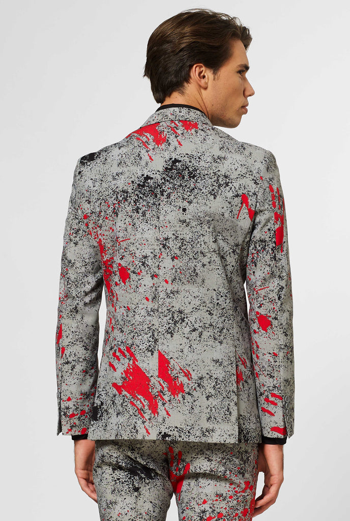 Man wearing grey Halloween men's suit with blood stains, view from the back