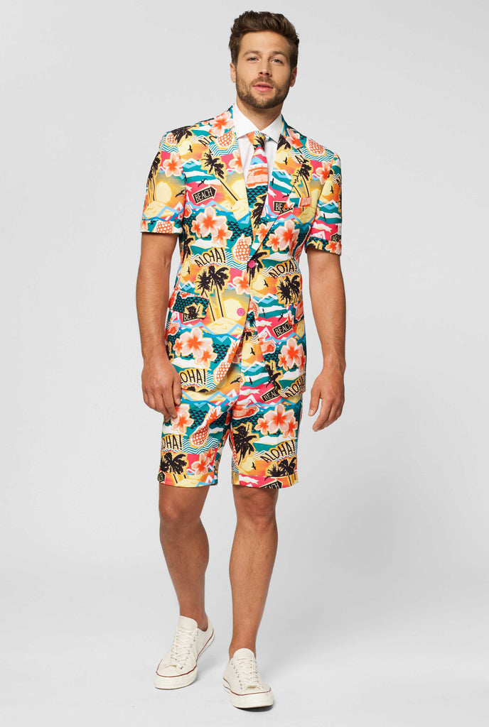 Man wearing colorful Hawaiian print summer suit, consisting of short, jacket and tie