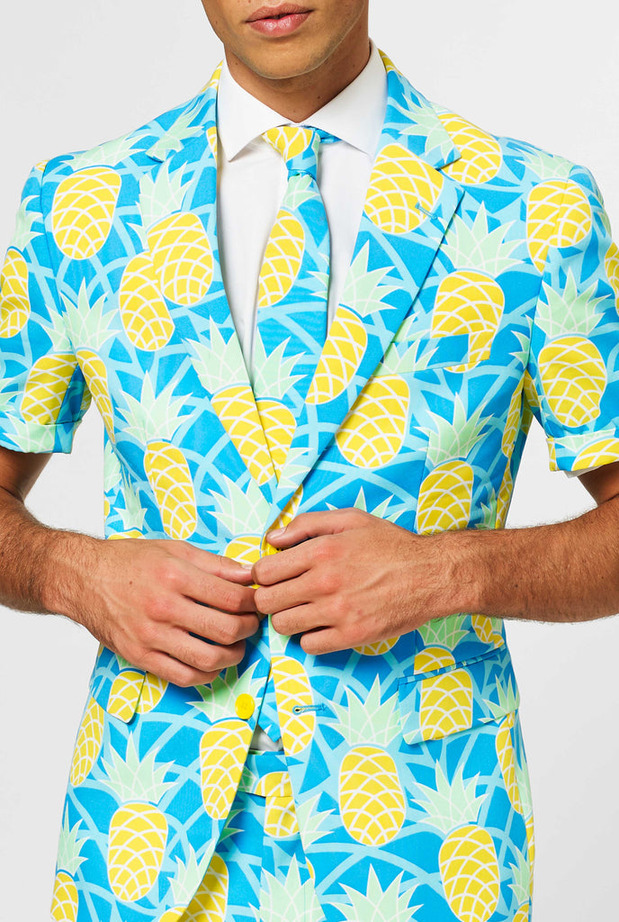 Man wearing blue summer suit with pineapple print, close up