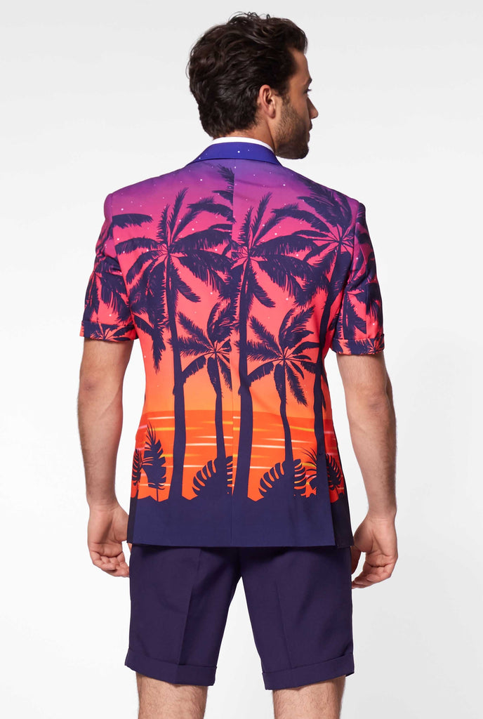 Man wearing summer suit with palms and sunset print, view from the back