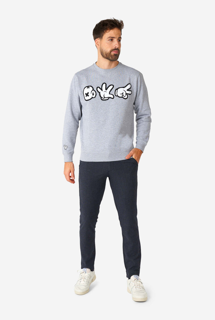 Man wearing grey sweater with chenille rock, paper, scissors embroidery