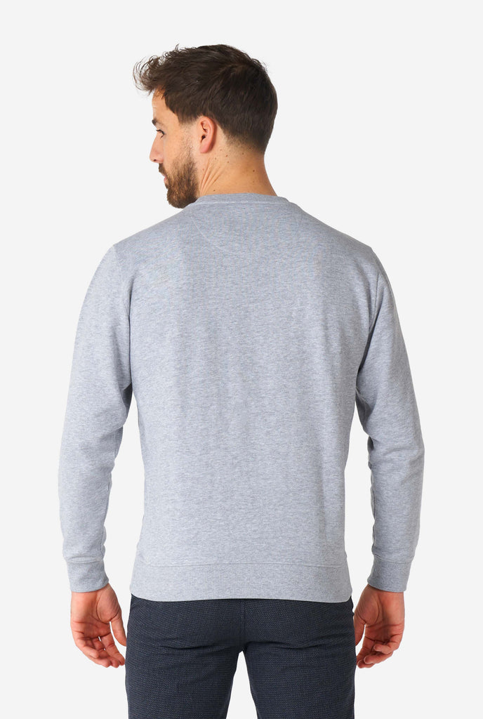 Man wearing grey sweater with chenille rock, paper, scissors embroidery, view from the back