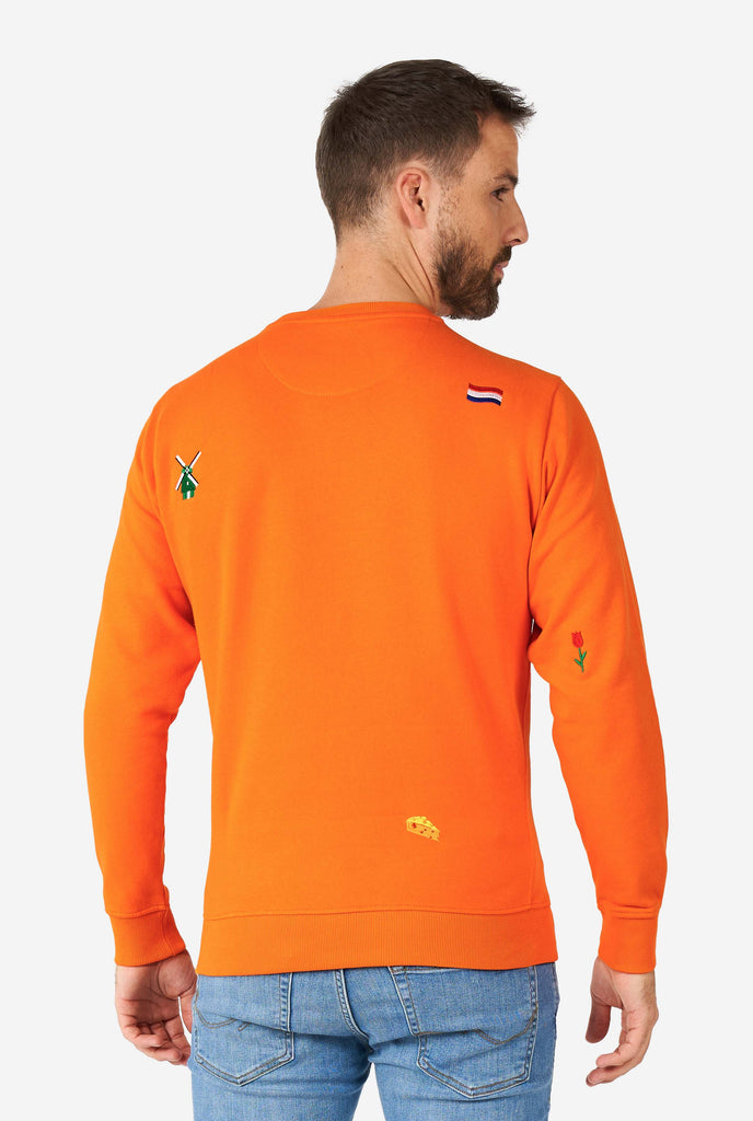 Man wearing orange sweater with Dutch icons, view from the back