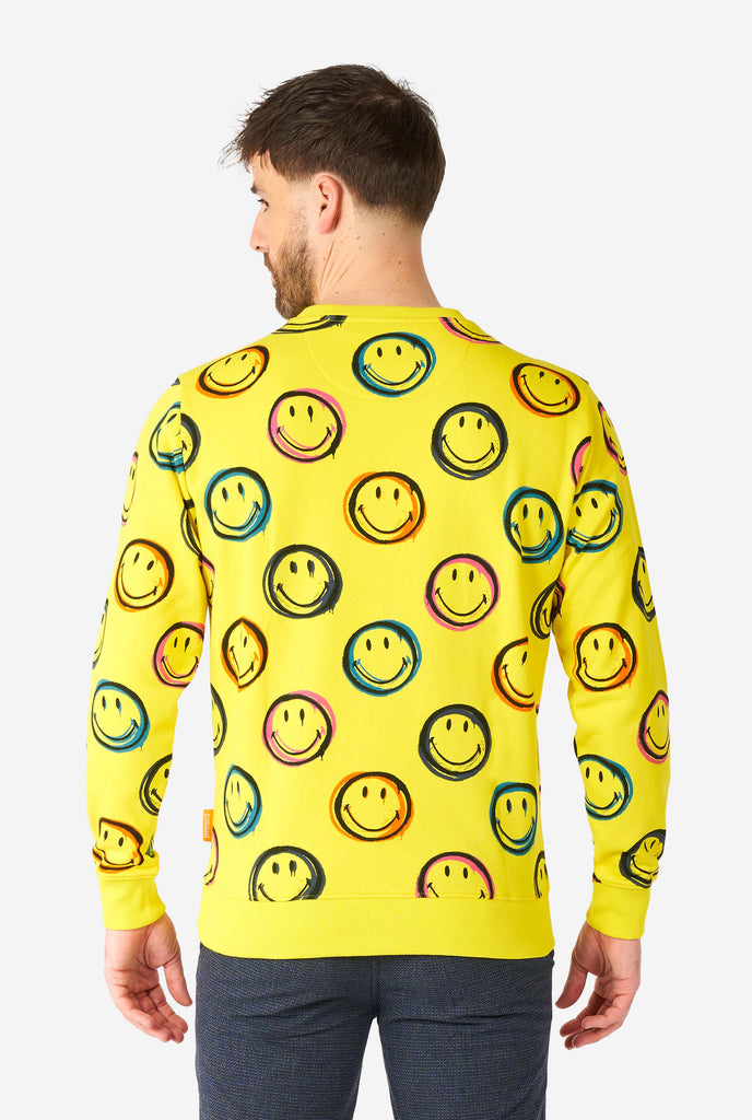 Man wearing yellow men's sweater with Smiley print, view from the back