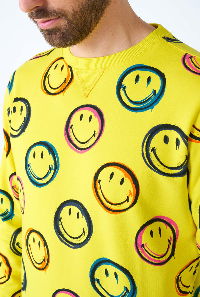 Man wearing yellow men's sweater with Smiley print, close up