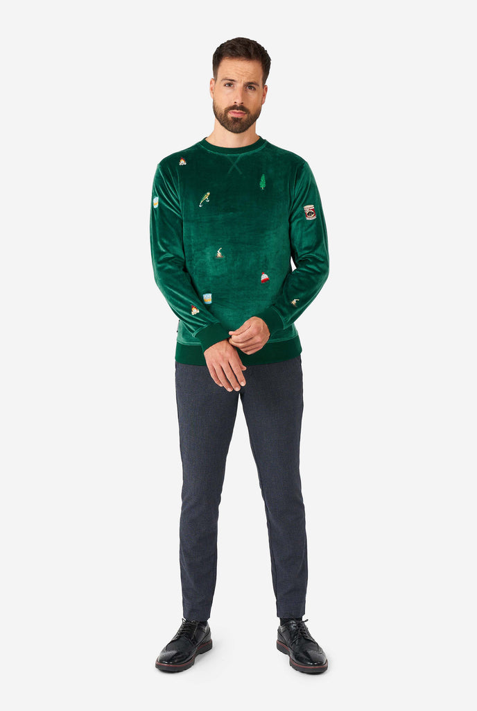 Man wearing velvet green Christmas sweater with Christmas icons