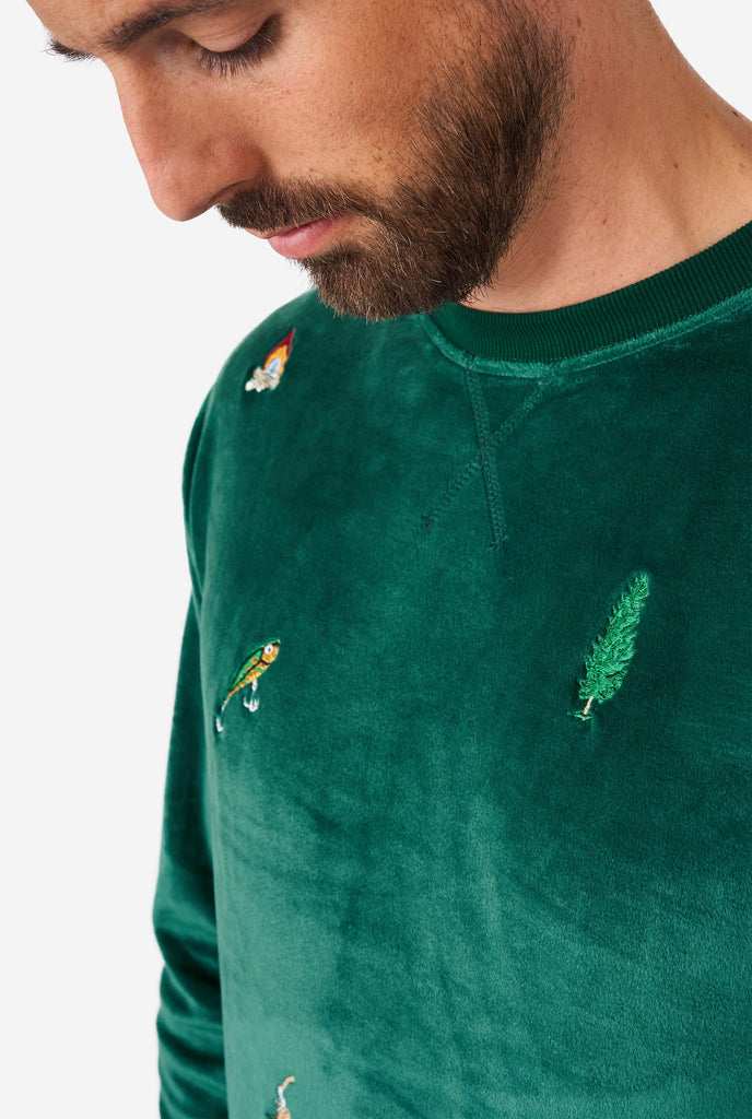 Man wearing velvet green Christmas sweater with Christmas icons, close up