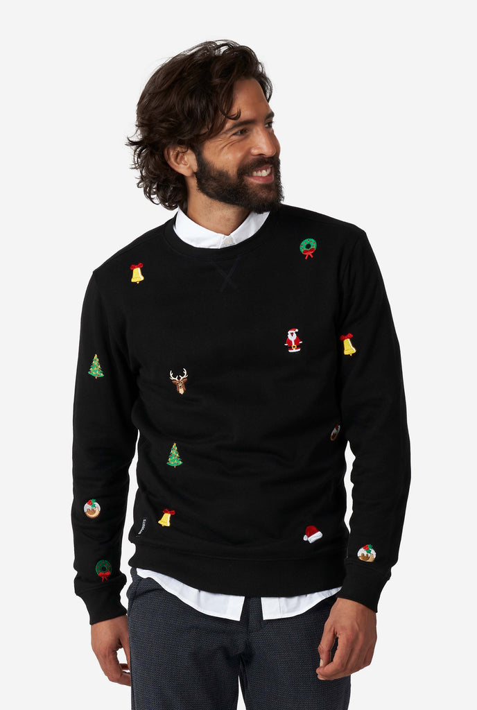 Man wearing black Christmas sweater with Christmas icons