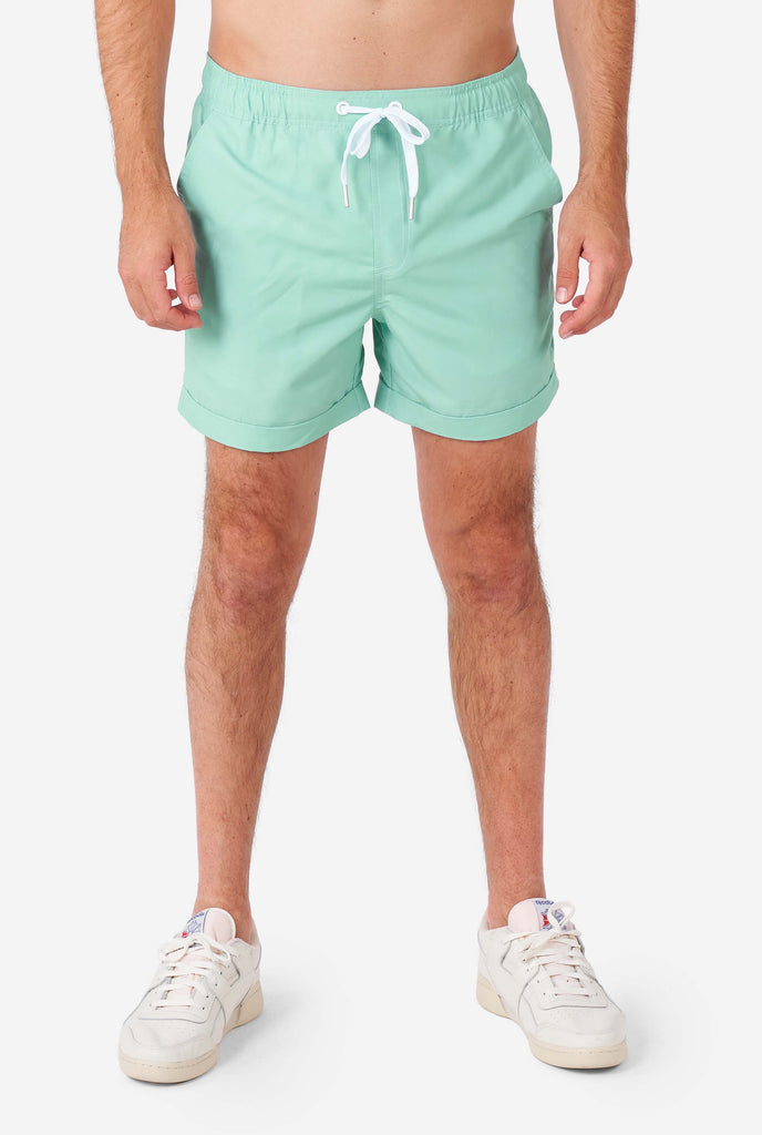 Man wearing green summer set, consisting of short sleeve shirt and shorts.