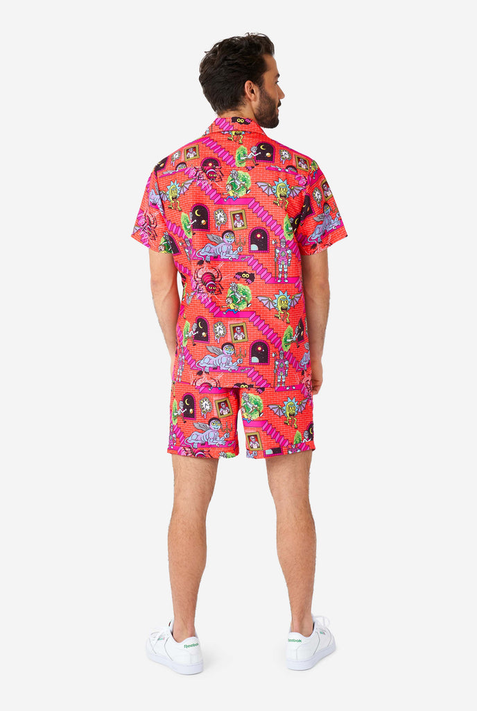 Man wearing summer outfit, consisting of short and shirt, with Rick and Morty print, view from the back