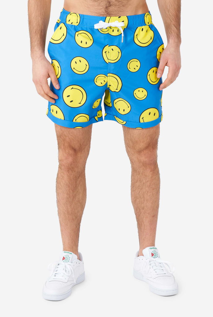 Man wearing blue shorts with Smiley print