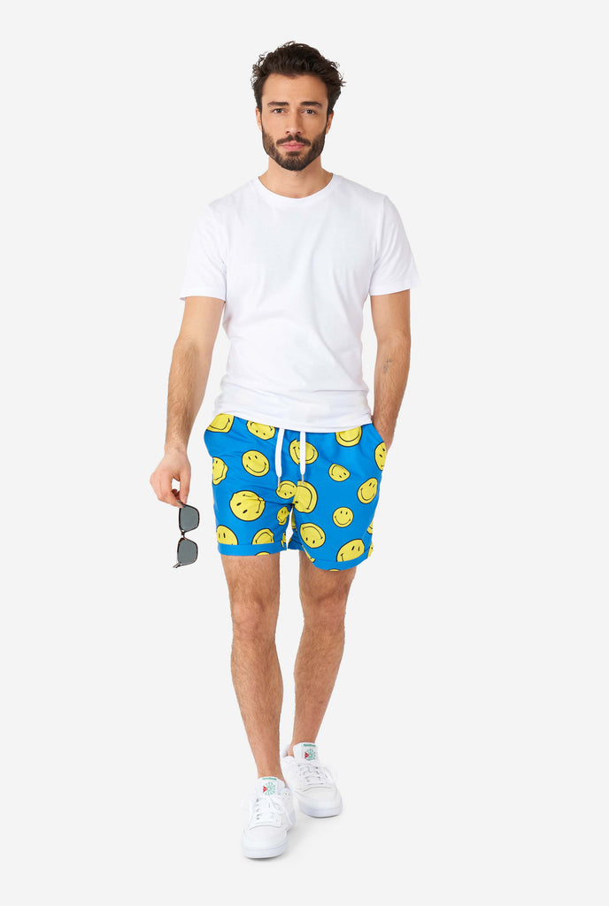 Man wearing part of blue summer set, consisting of shorts and shirt, with Smiley print