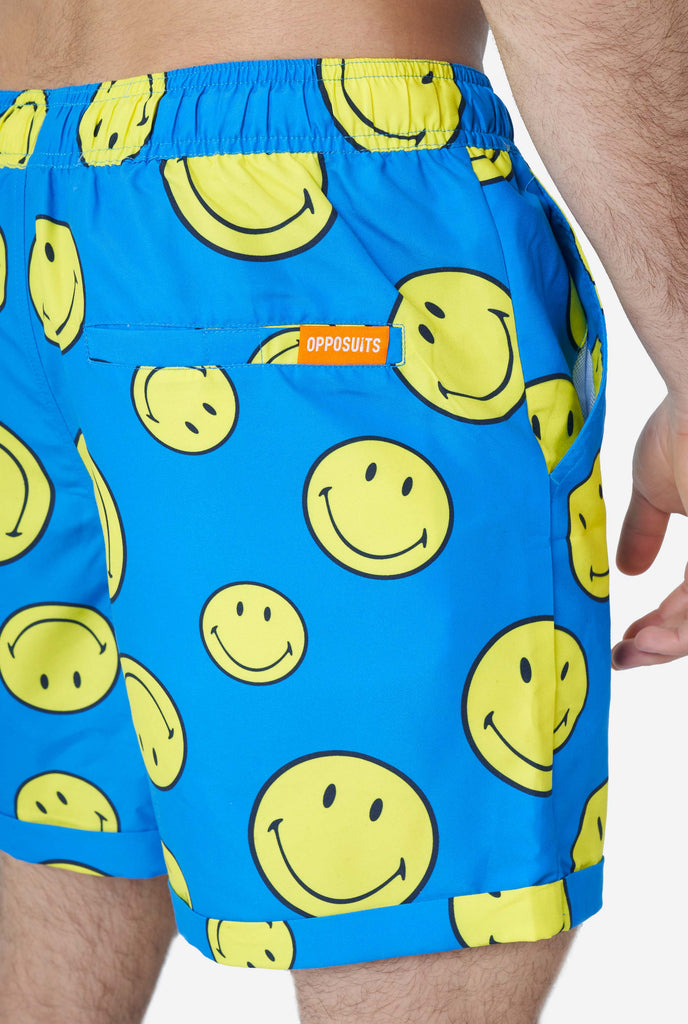 Man wearing blue summer set, consisting of shorts and shirt, with Smiley print, shorts close up